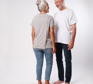 femme de dos en t-shirt gris et homme en t-shirt blanc qui la regarde