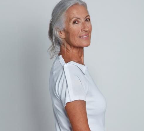 femme de profil en t-shirt blanc ouvert sur les épaules par bandes d'aimants